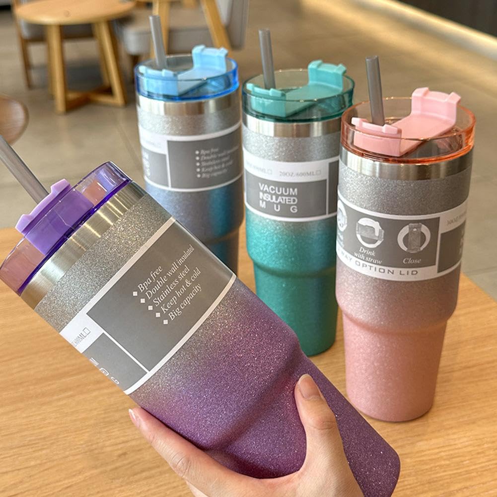 Set of colorful tumblers with straws on a wooden table.