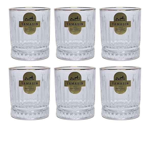 Set of six clear glasses with gold rims on a white background