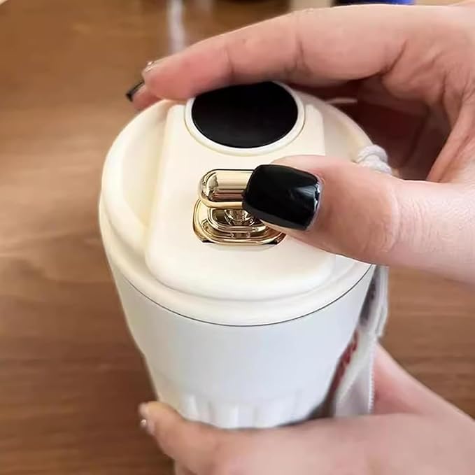 Hand holding a white electronic device with a black button on a wooden surface