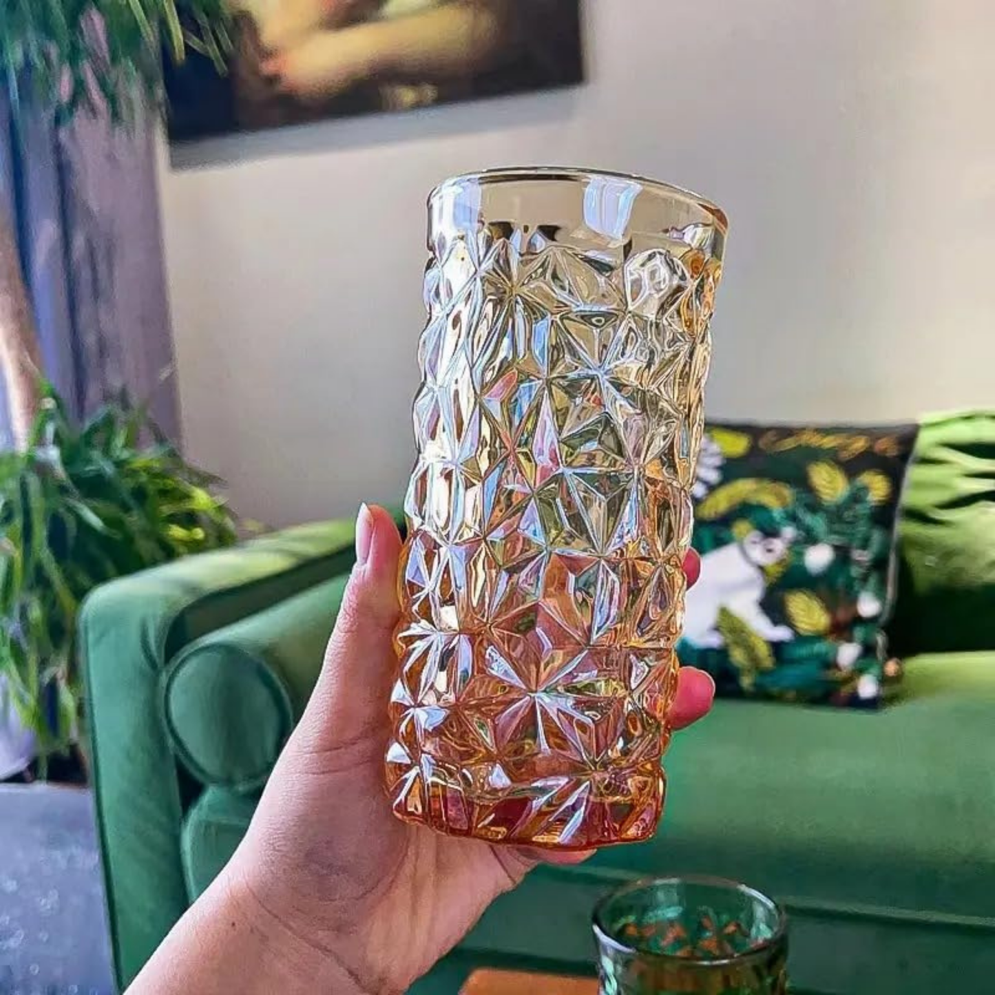 Hand holding a textured glass vase in a living room setting