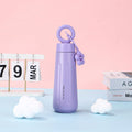 Purple water bottle with a pink lid on a light blue surface with a pink background