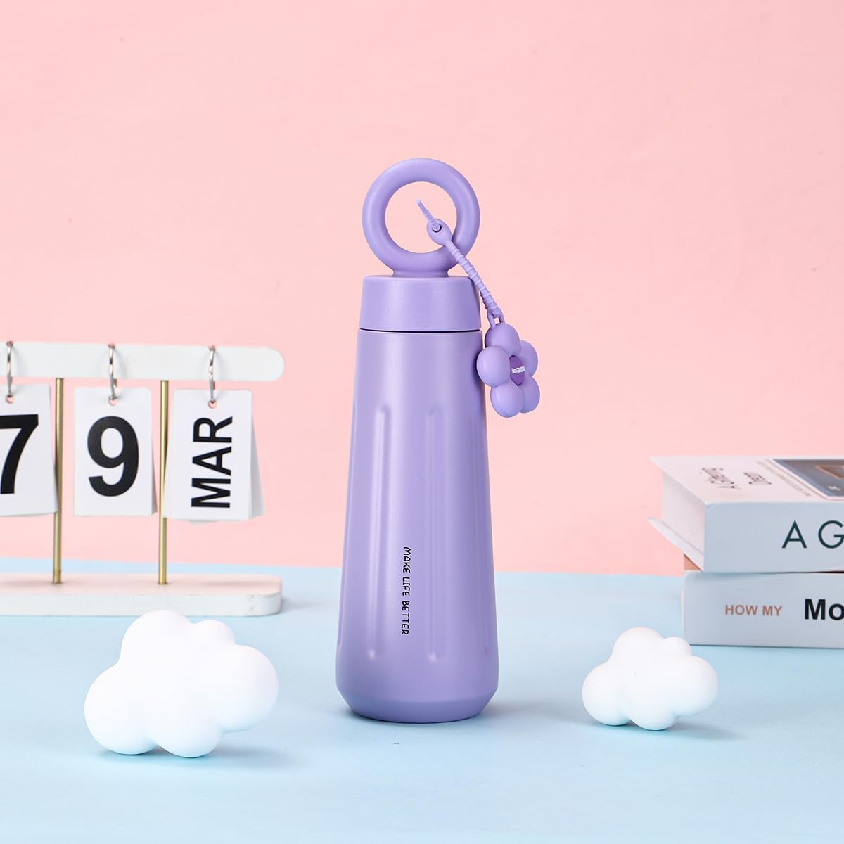 Purple water bottle with a pink lid on a light blue surface with a pink background
