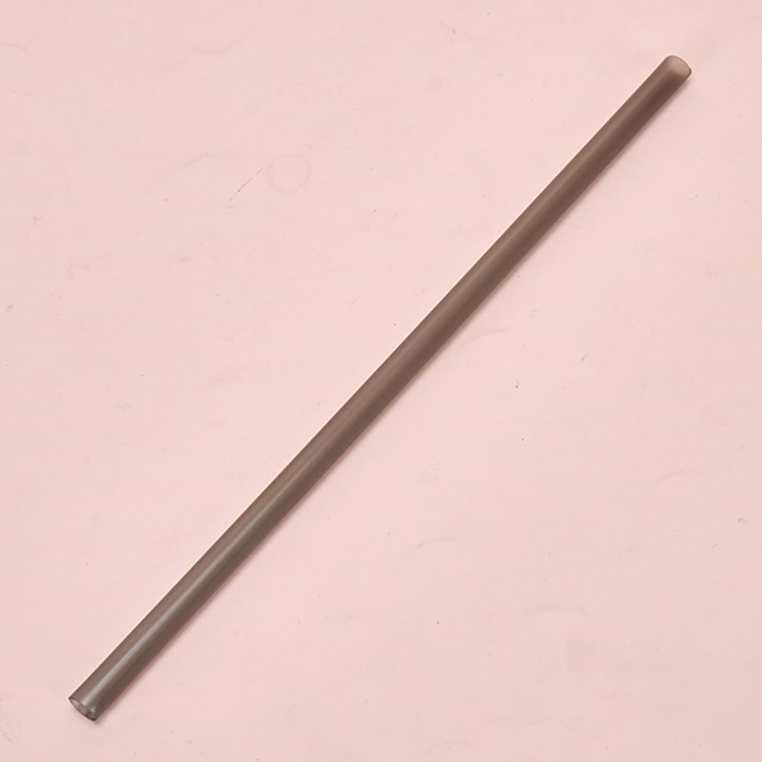 Long, thin metallic rod on a pink background