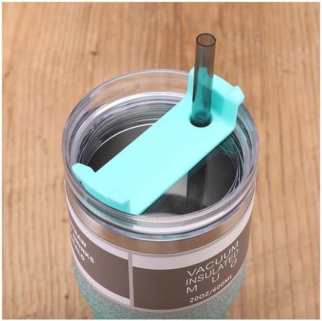 Vacuum insulated mug with a turquoise straw lid on a wooden surface