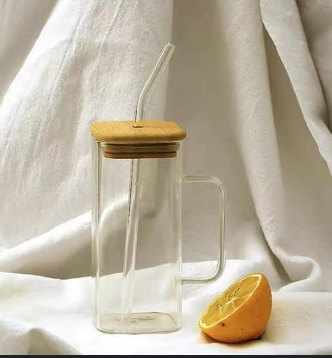Clear glass mug with wooden lid and straw on a white fabric background