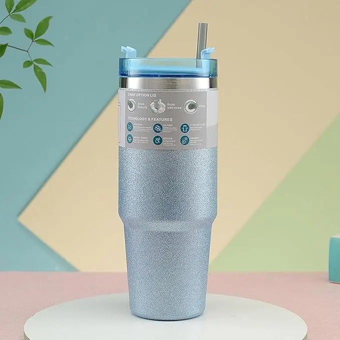 Blue glittery tumbler with a straw on a colorful geometric background