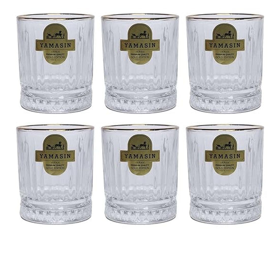 Set of six clear glasses with gold rims  on a white background