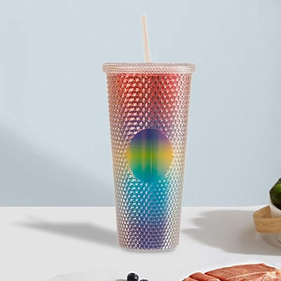Gradient-colored tumbler with a straw on a light blue background