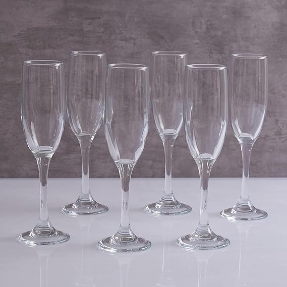 Set of six clear wine glasses on a gray surface with a gray background