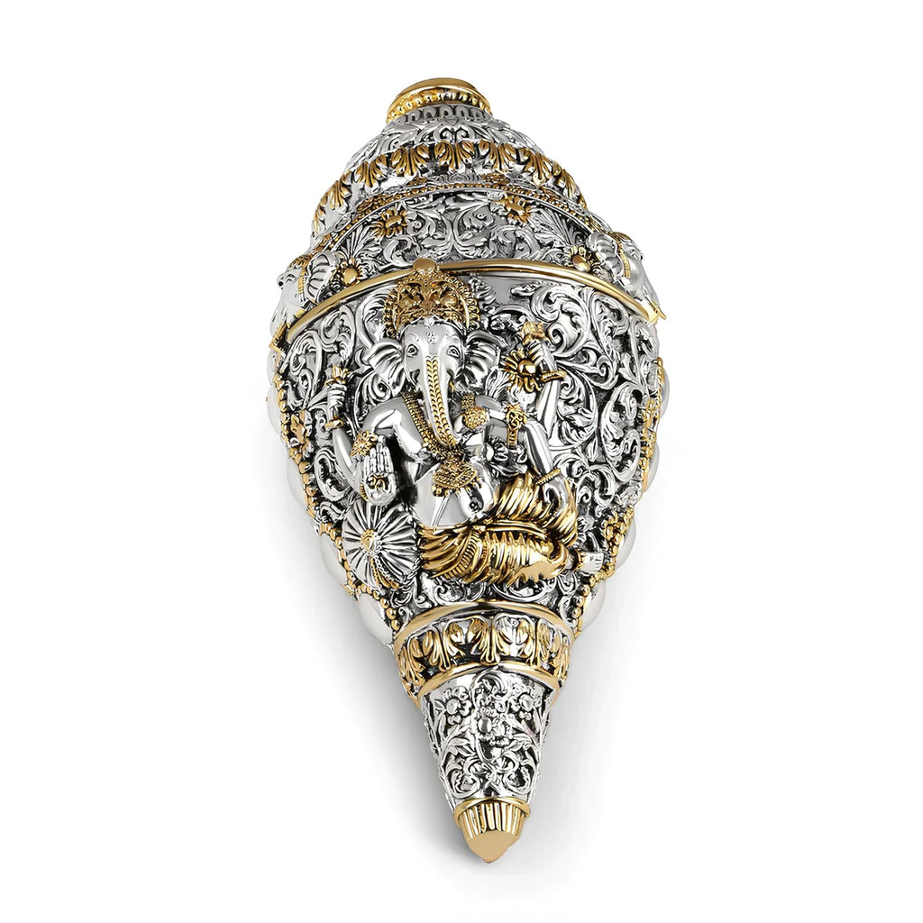 Decorative shell with intricate gold and silver design on a white background