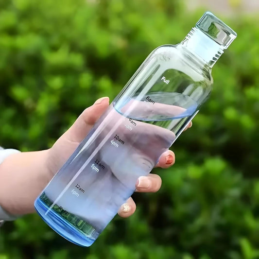 Hand holding a clear water bottle with measurement markings against a green outdoor background