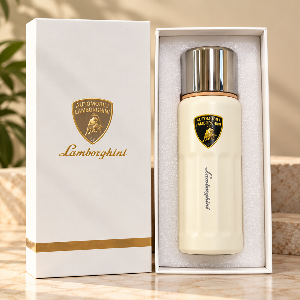 A Lamborghini-branded cream-colored bottle with a silver cap displayed inside an open white gift box next to its matching outer box, set on a marble surface with a softly blurred background.