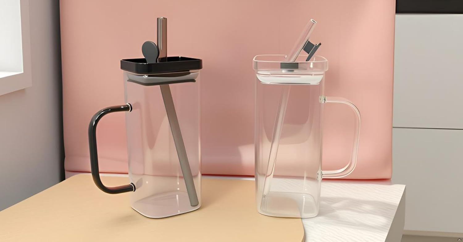 Two clear plastic pitchers with black handles and lids on a light wooden surface.