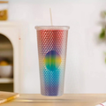 Tumbler with a colorful, textured design on a blurred background