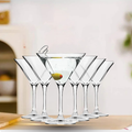Set of clear martini glasses with a drink on a wooden surface.