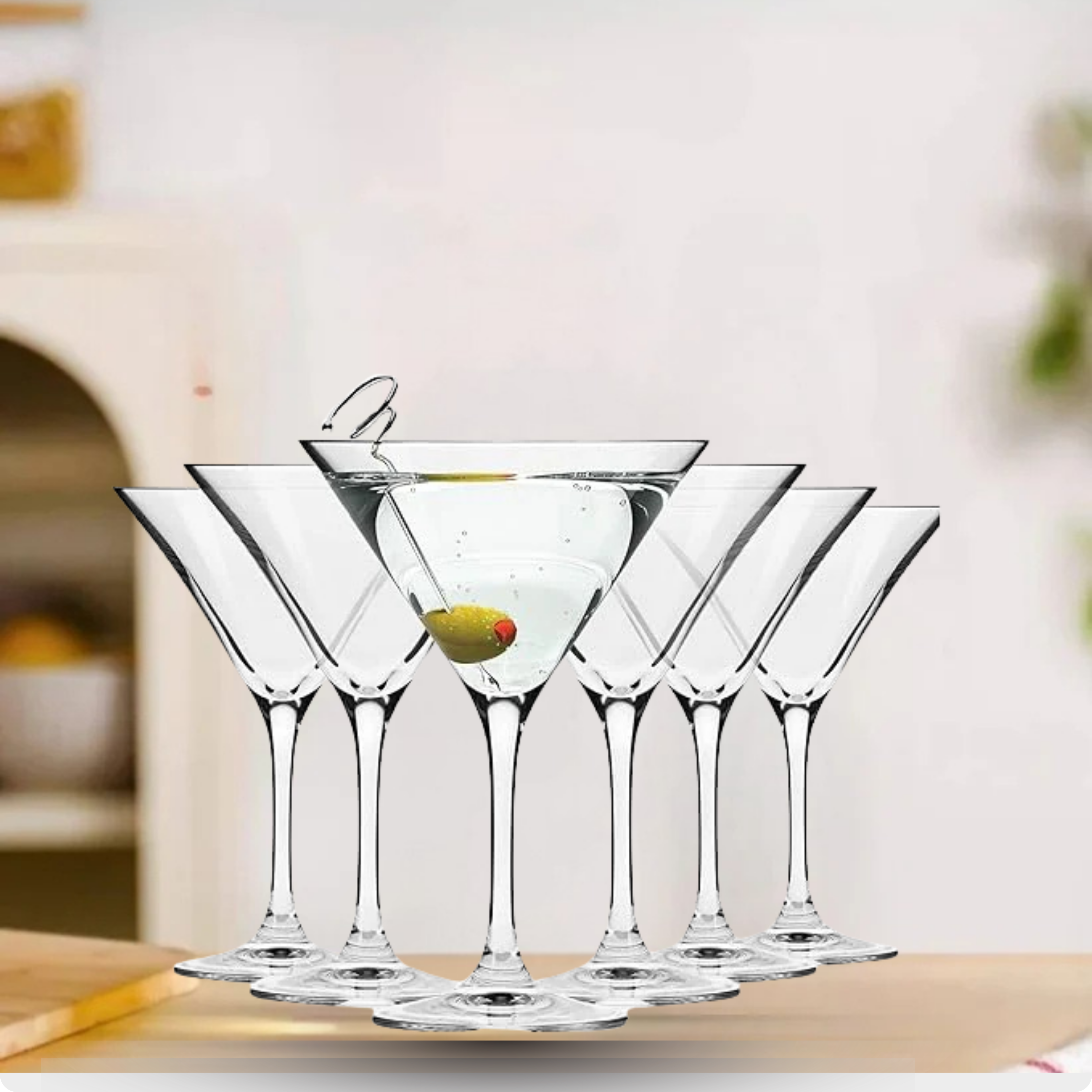 Set of clear martini glasses with a drink on a wooden surface.